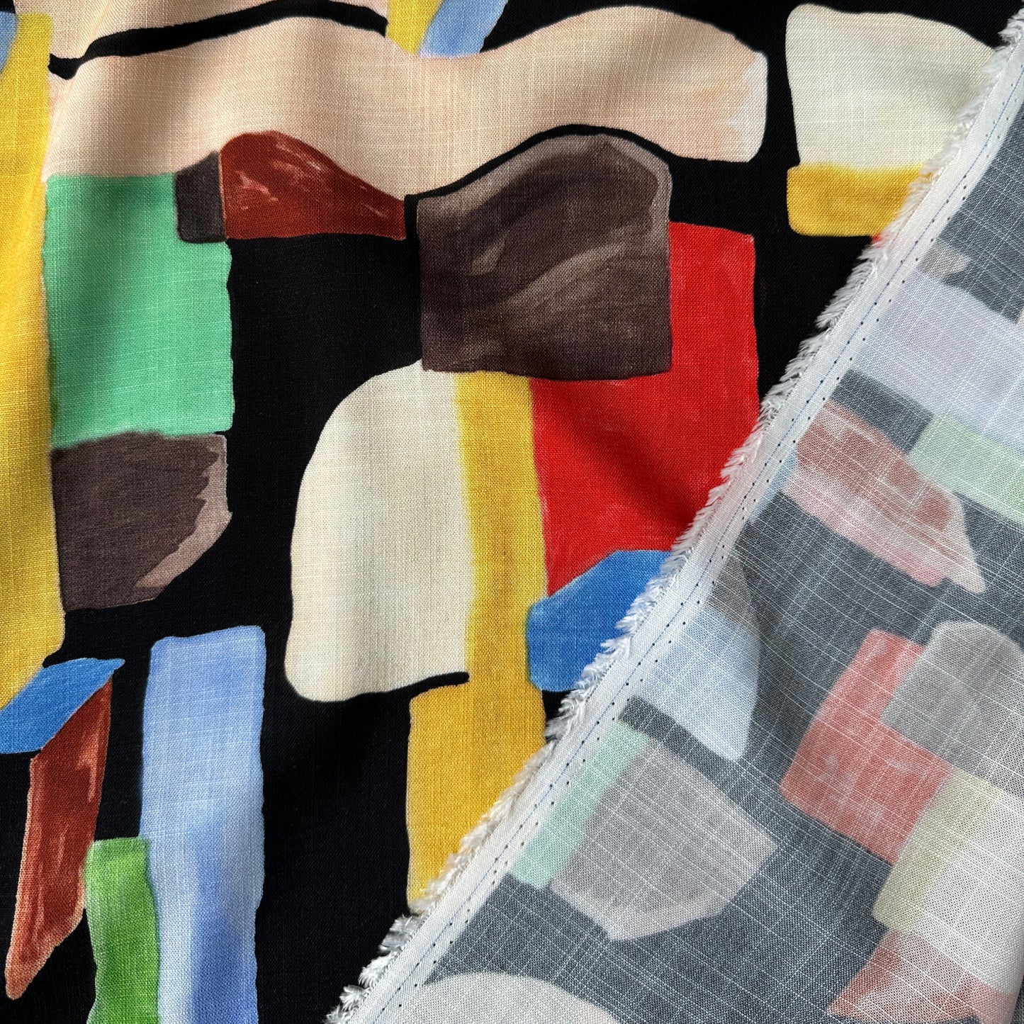 Abstract fabric with geometric shapes in various colours on a black background