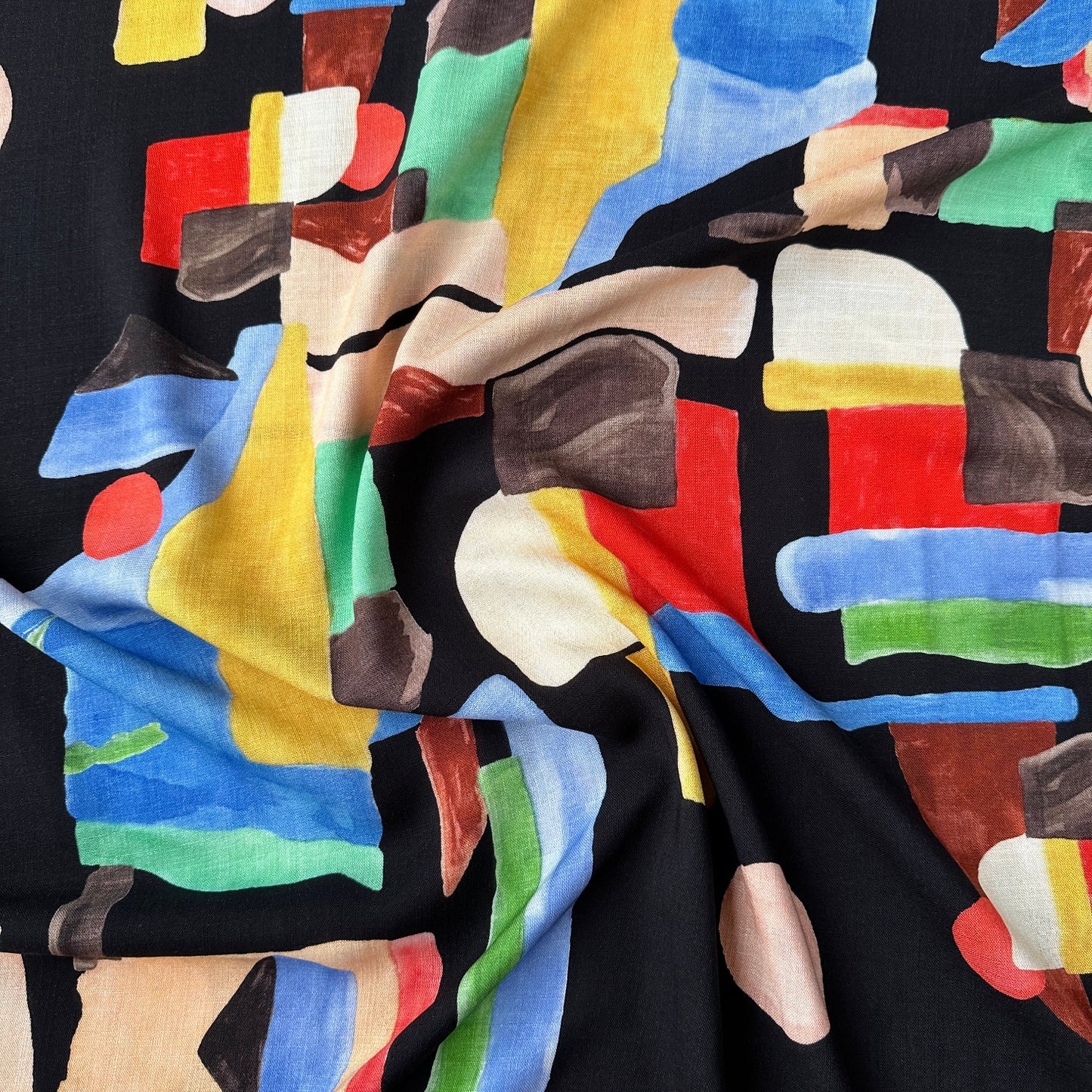 Colourful abstract pattern on black viscose fabric