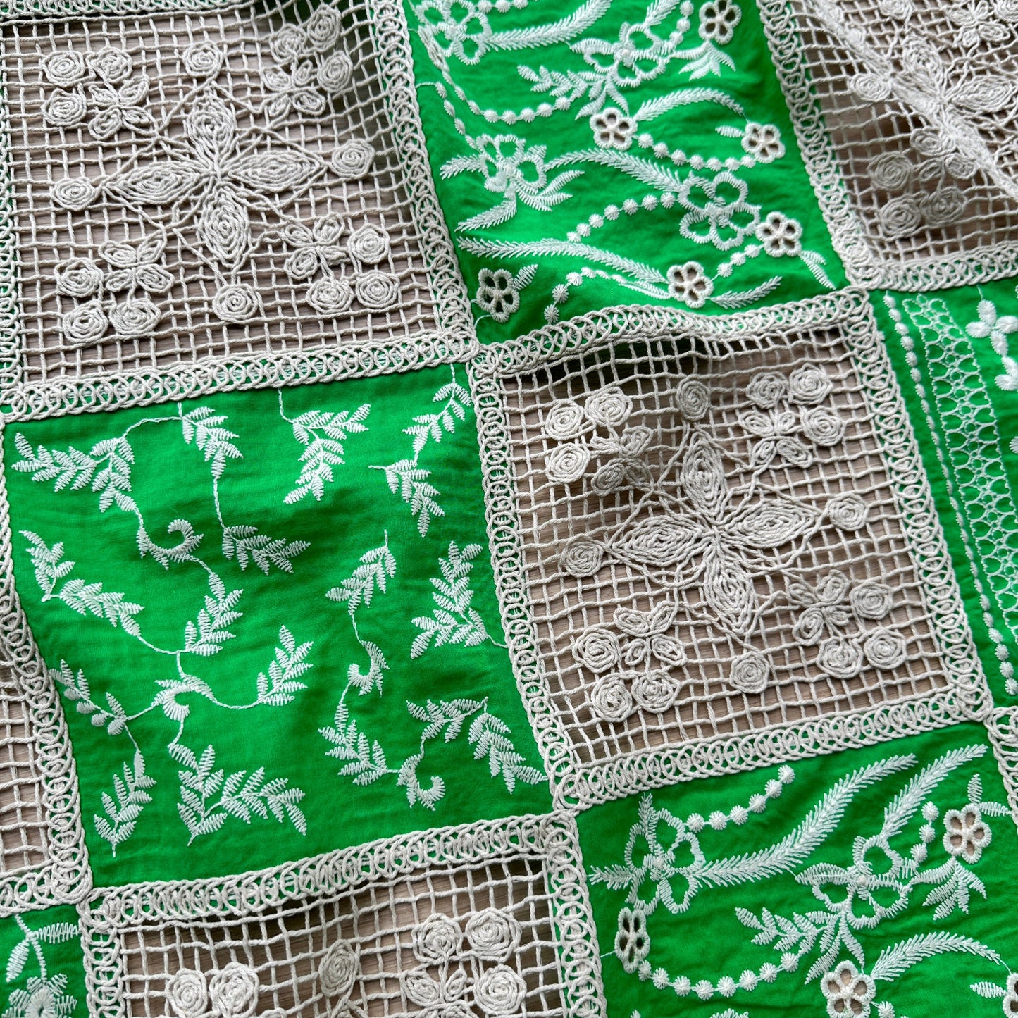Green dressmaking fabric with embroidery and crochet panels