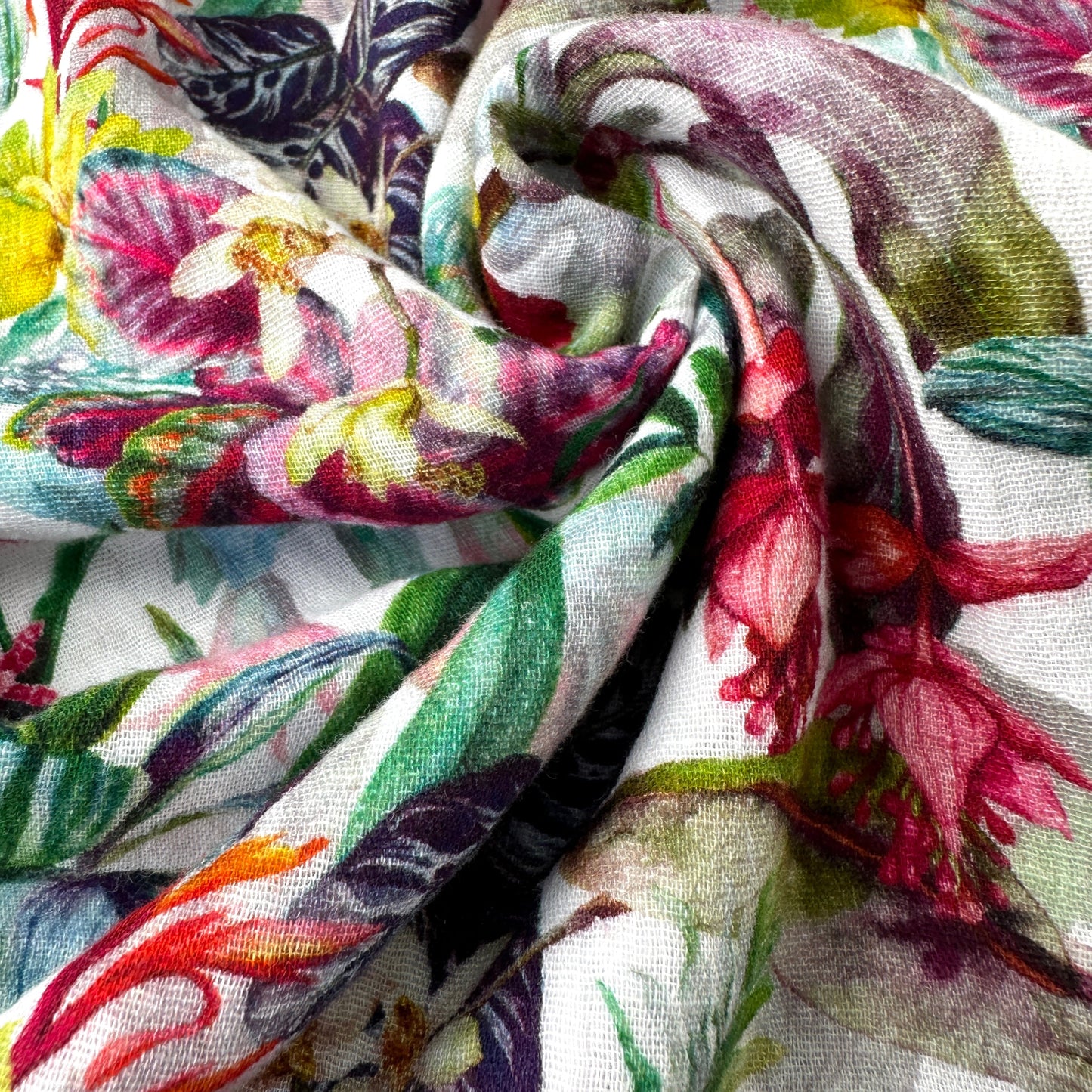 Close-up of floral fabric with colourful flowers and leaves on a white background