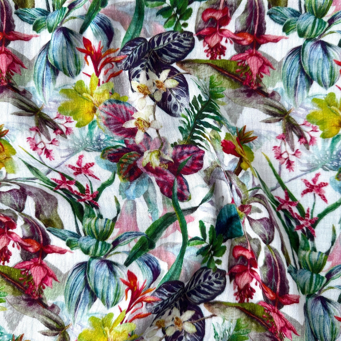 Double gauze fabric with colourful flowers across a white background