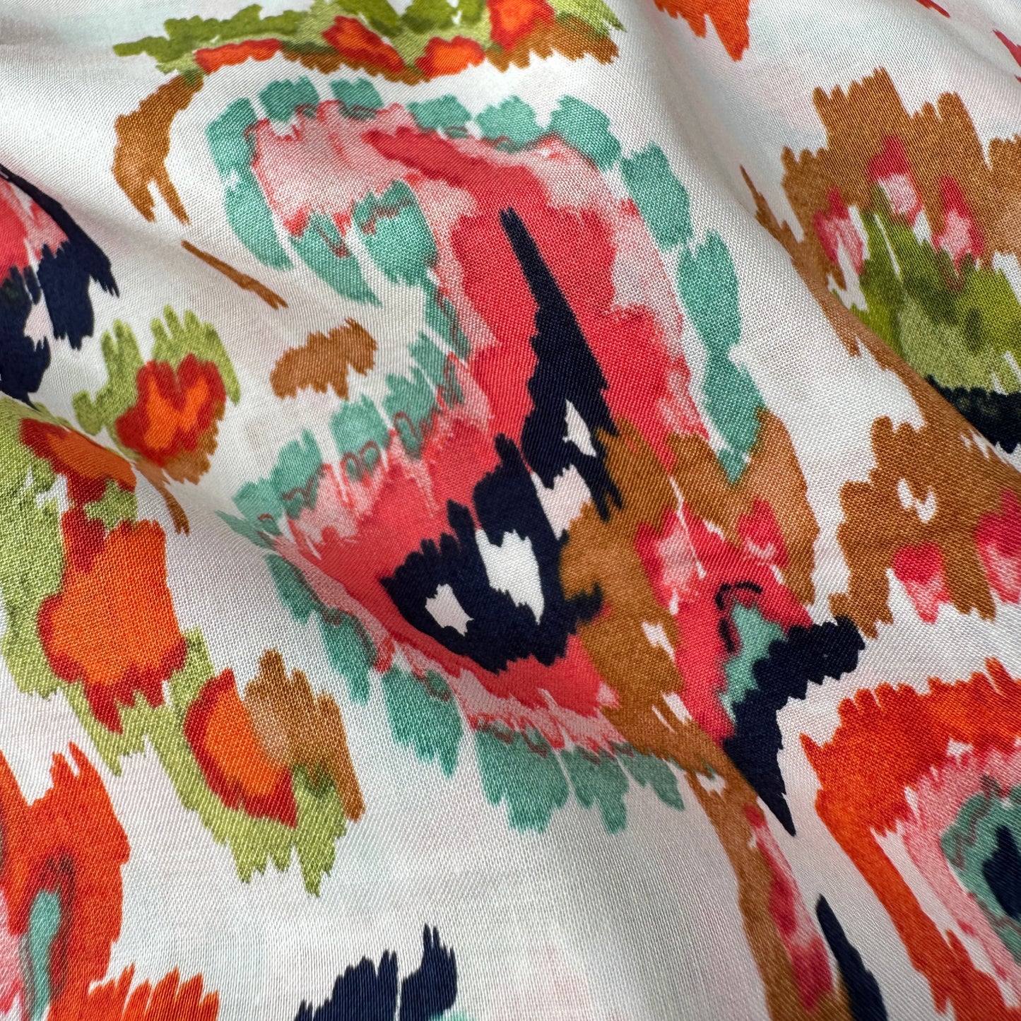 Close up of colourful Paisley fabric with an off white background
