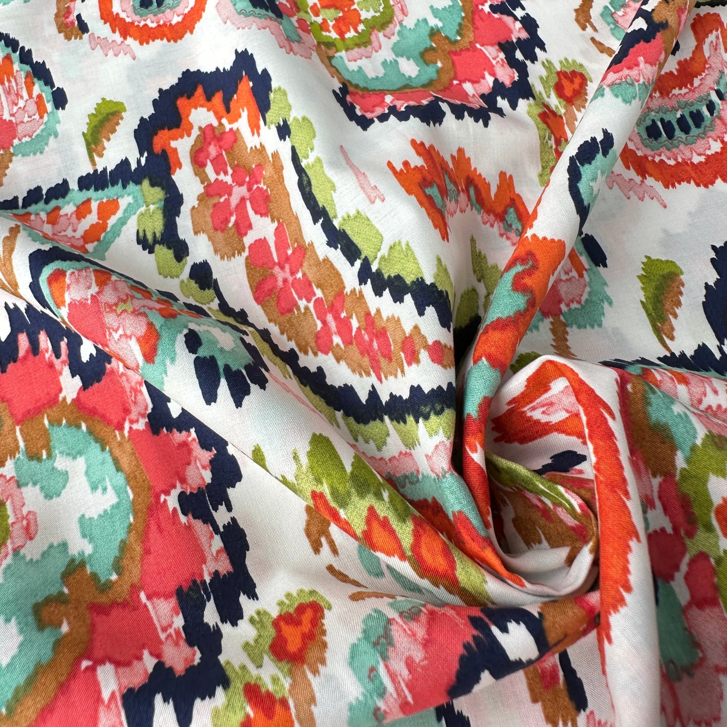 Watercolour paisley cotton lawn fabric in coral close up