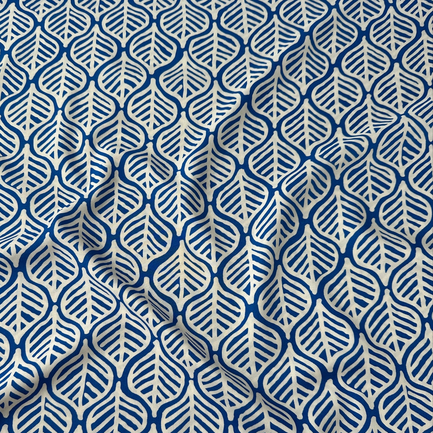 White leaves on cobalt blue viscose dressmaking fabric