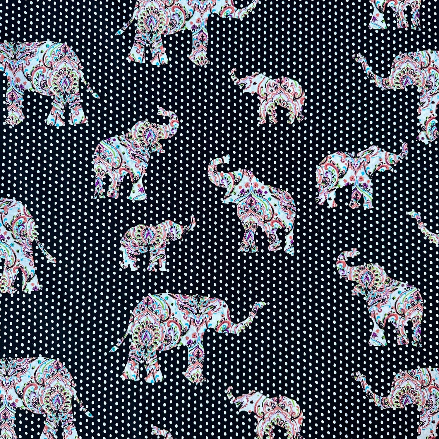 Cotton poplin fabric with a black and white polka dot background and then elephants of varying size across it with a paisley design in them 