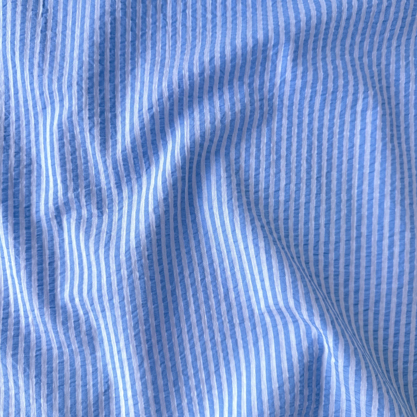 close up of Baby Blue and White Striped Cotton Seersucker Fabric
