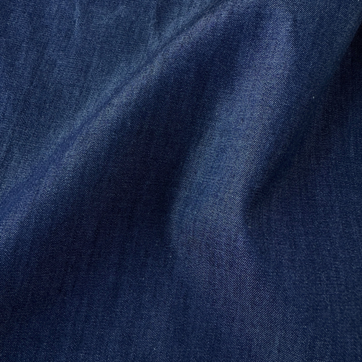 A close-up of dark blue fabric with soft folds 