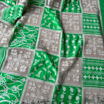 Green patchwork dressmaking fabric with embroidered and crocheted panels