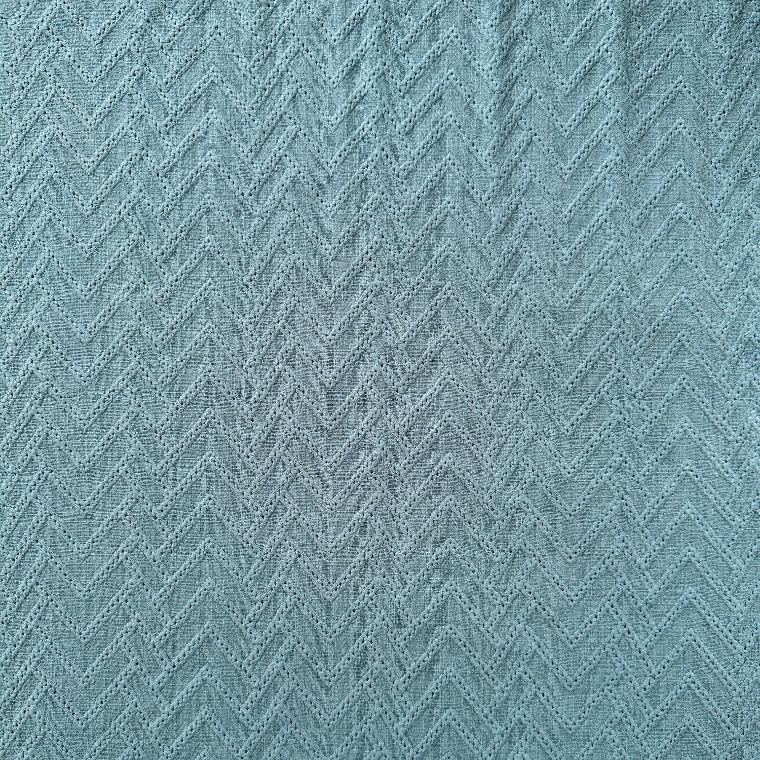 A close-up of a textured fabric with a zigzag pattern in blue