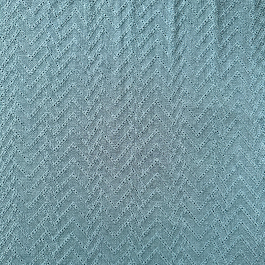 A close-up of a textured fabric with a zigzag pattern in blue