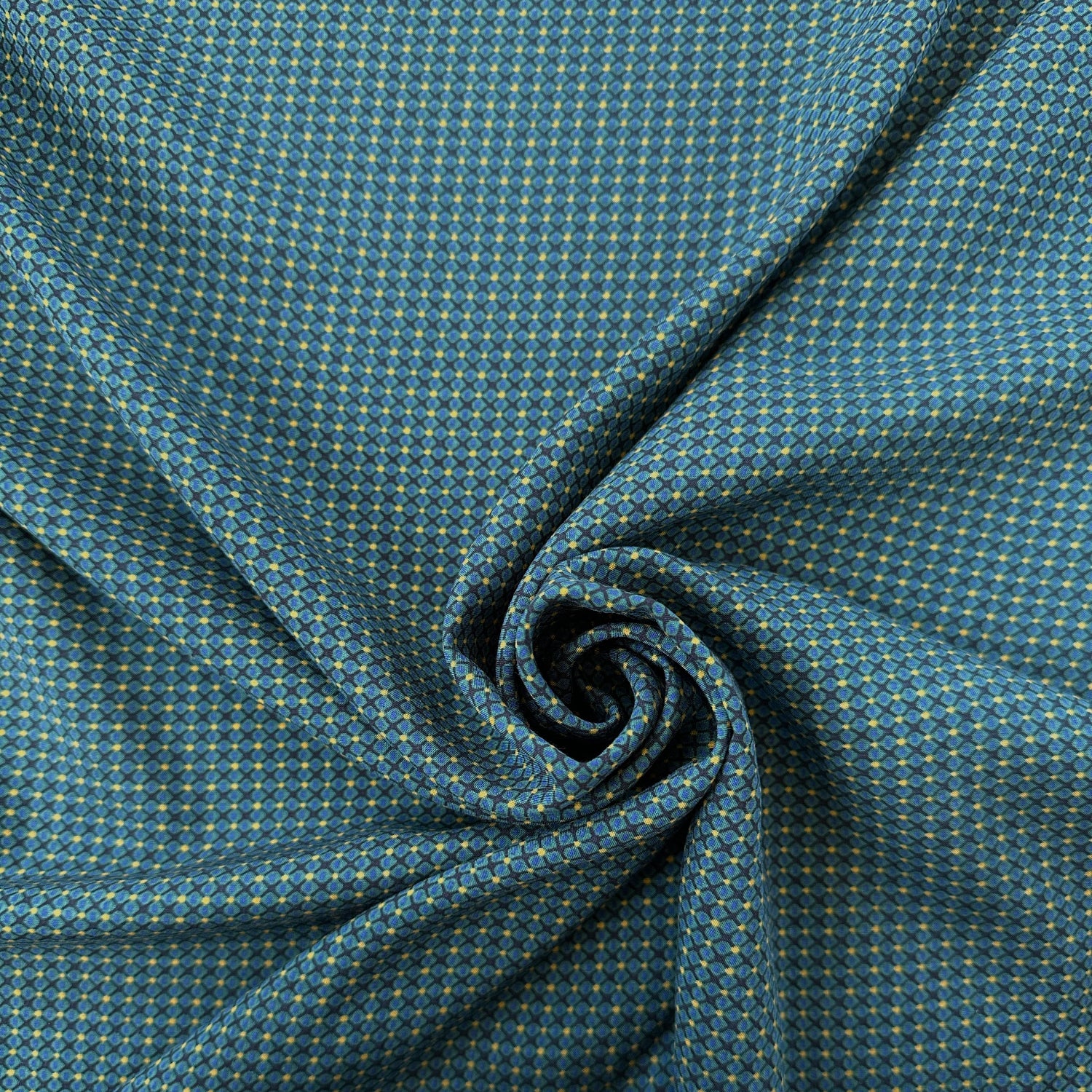 Swirl of lightweight lyocell dressmaking fabric in dark teal with yellow spots