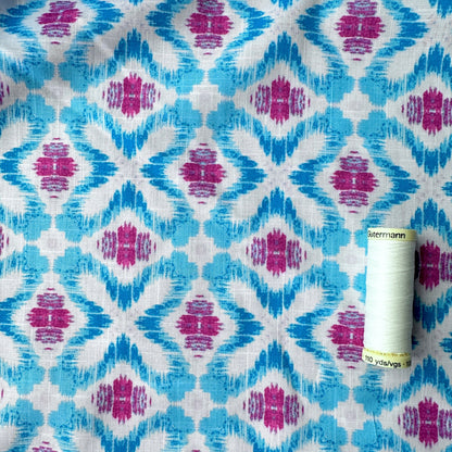 Reel of thread showing scale of ikat design on this dressmaking fabric