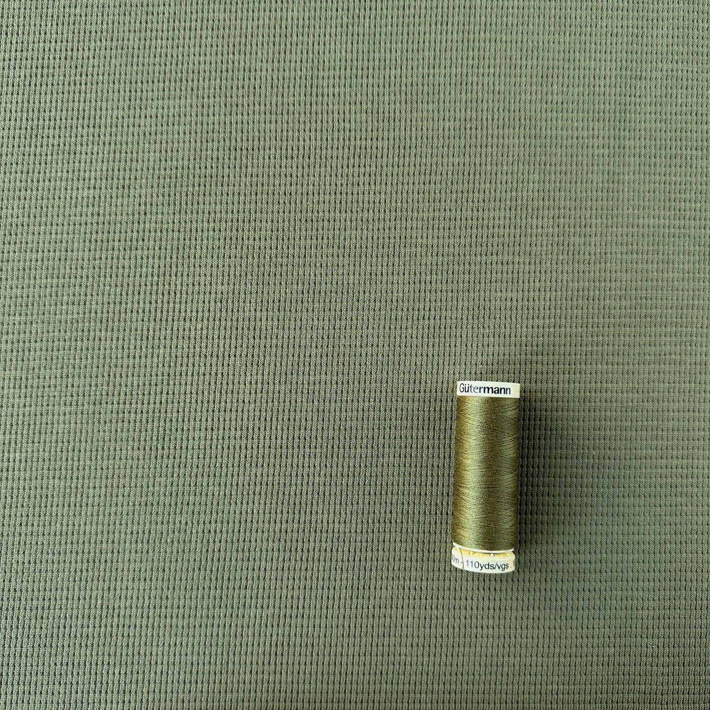 reel of thread showing scale of weave on waffle knit fabric
