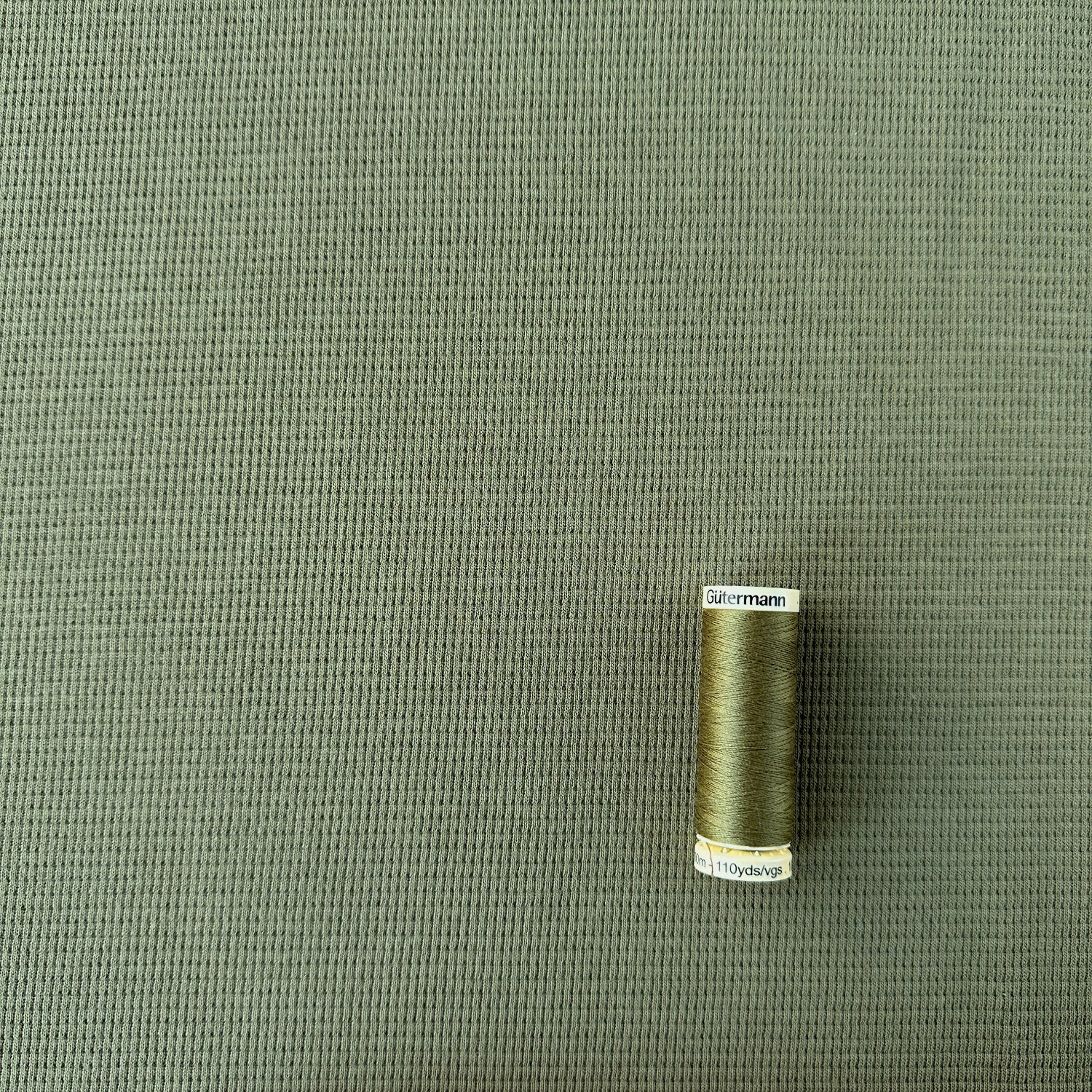 reel of thread showing scale of weave on waffle knit fabric