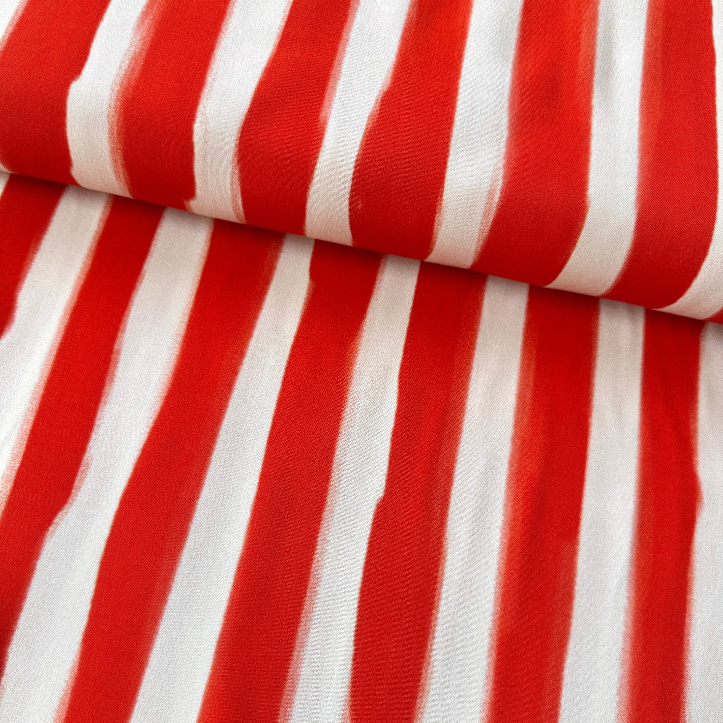 Painted stripes in orange/red on a light peach background