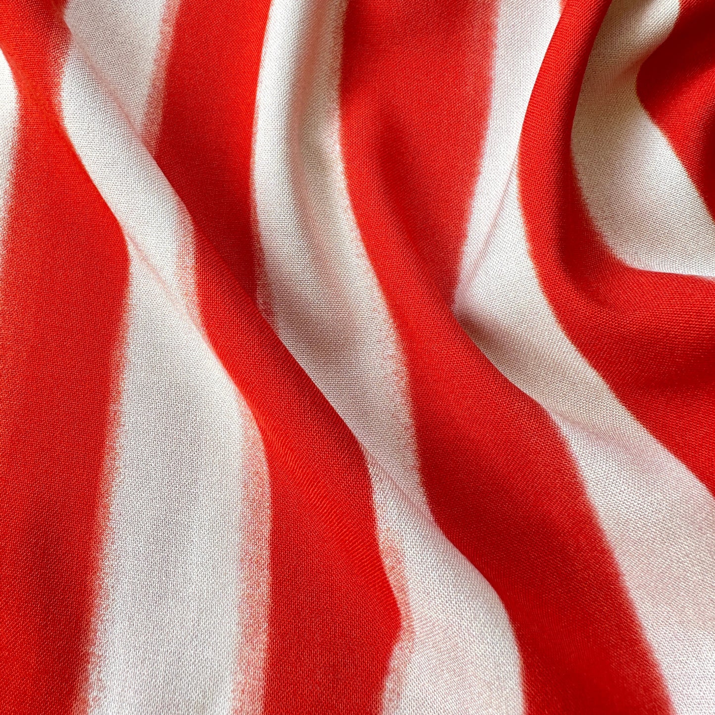 Pale peach and orangey red striped fabric