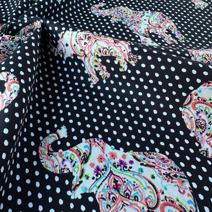 Fabric with polka dots and colourful paisley elephants on a black background