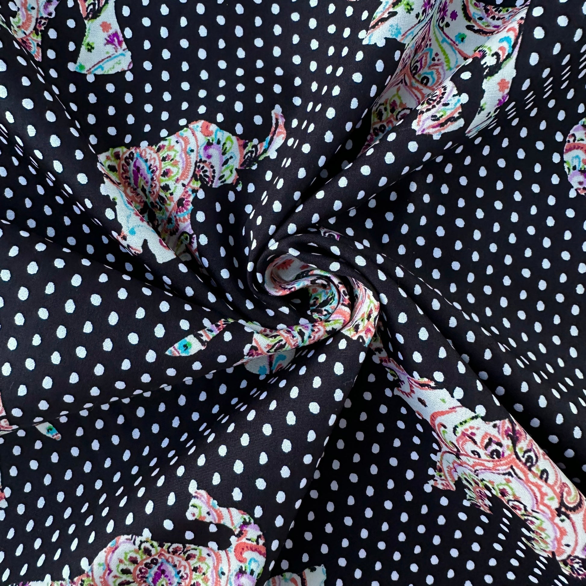 Fabric with paisley patterns and white polka dots on a black background
