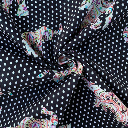 Fabric with paisley patterns and white polka dots on a black background