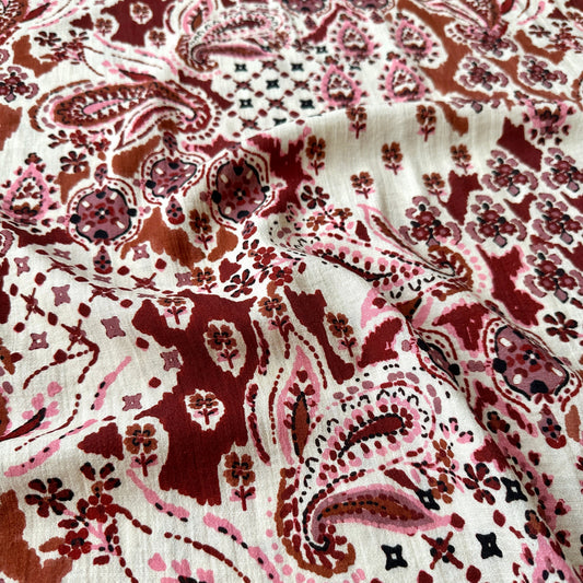 Fabric with a paisley design in browns pink cream and burgundy