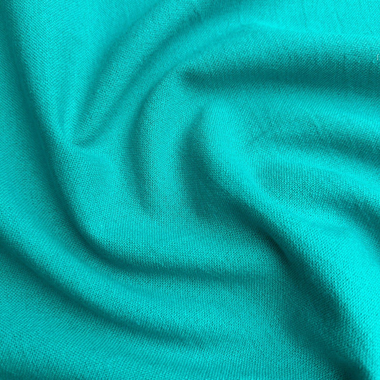 Close up of peacock cotton linen fabric with folds