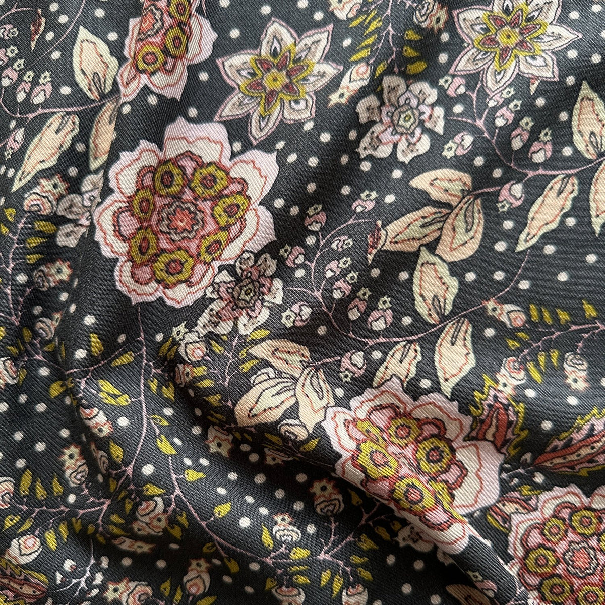 Close up of texture on viscose twill fabric with grey background and pink and lime green flowers