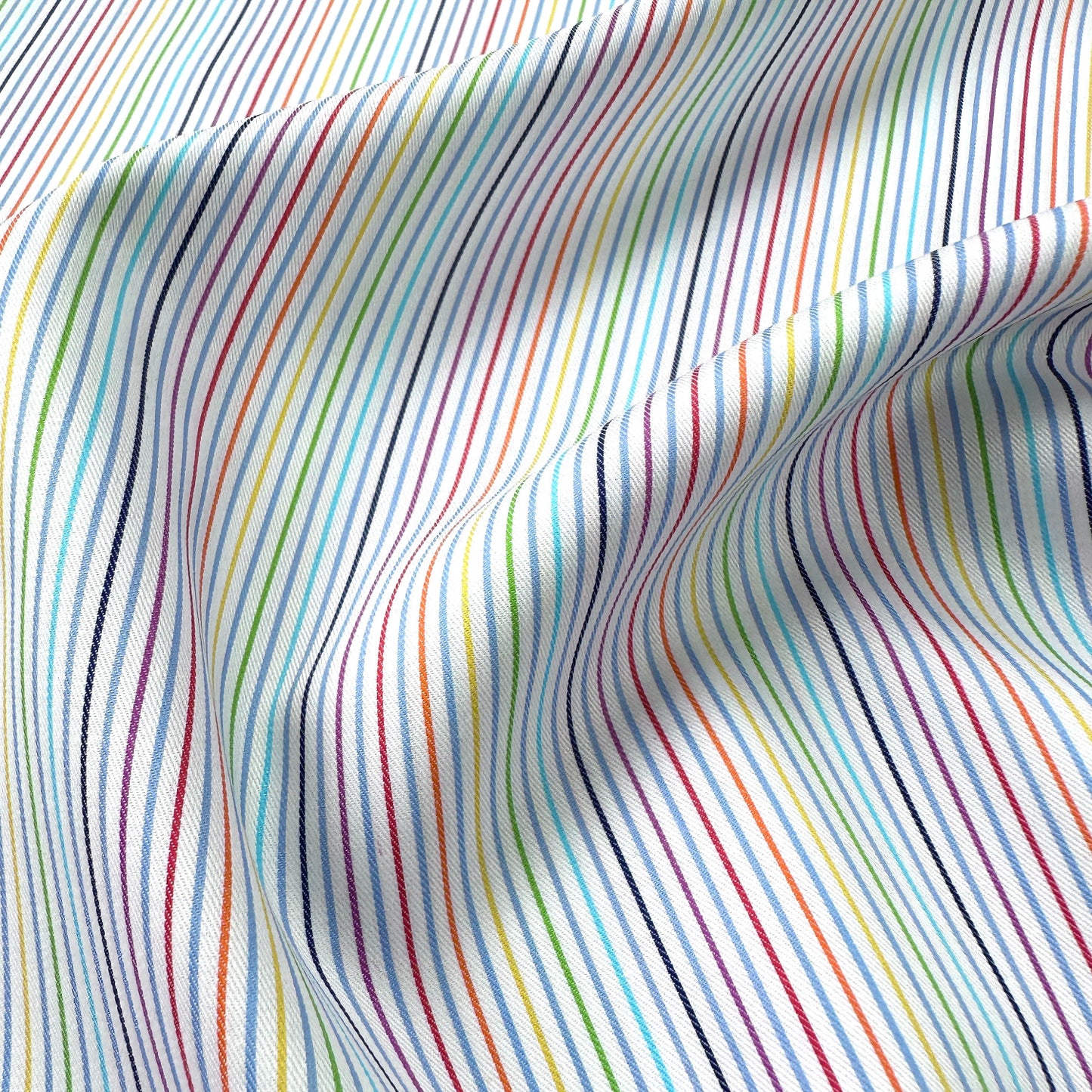 Close up of fabric with multicoloured stripes on a white background