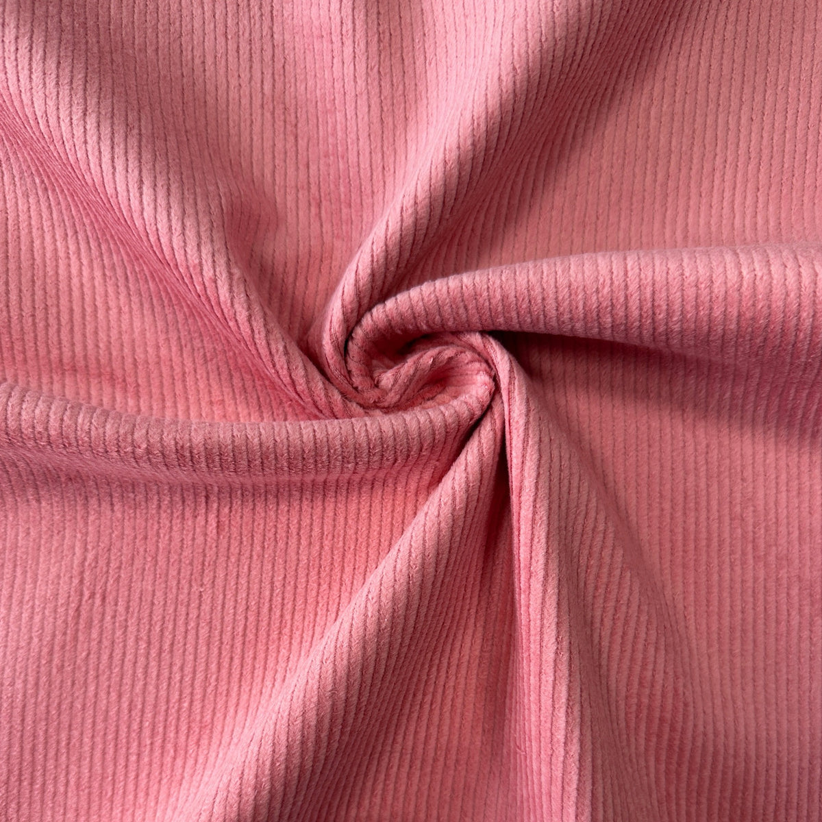 Old rose coloured stretch cotton corduroy fabric showing the texture