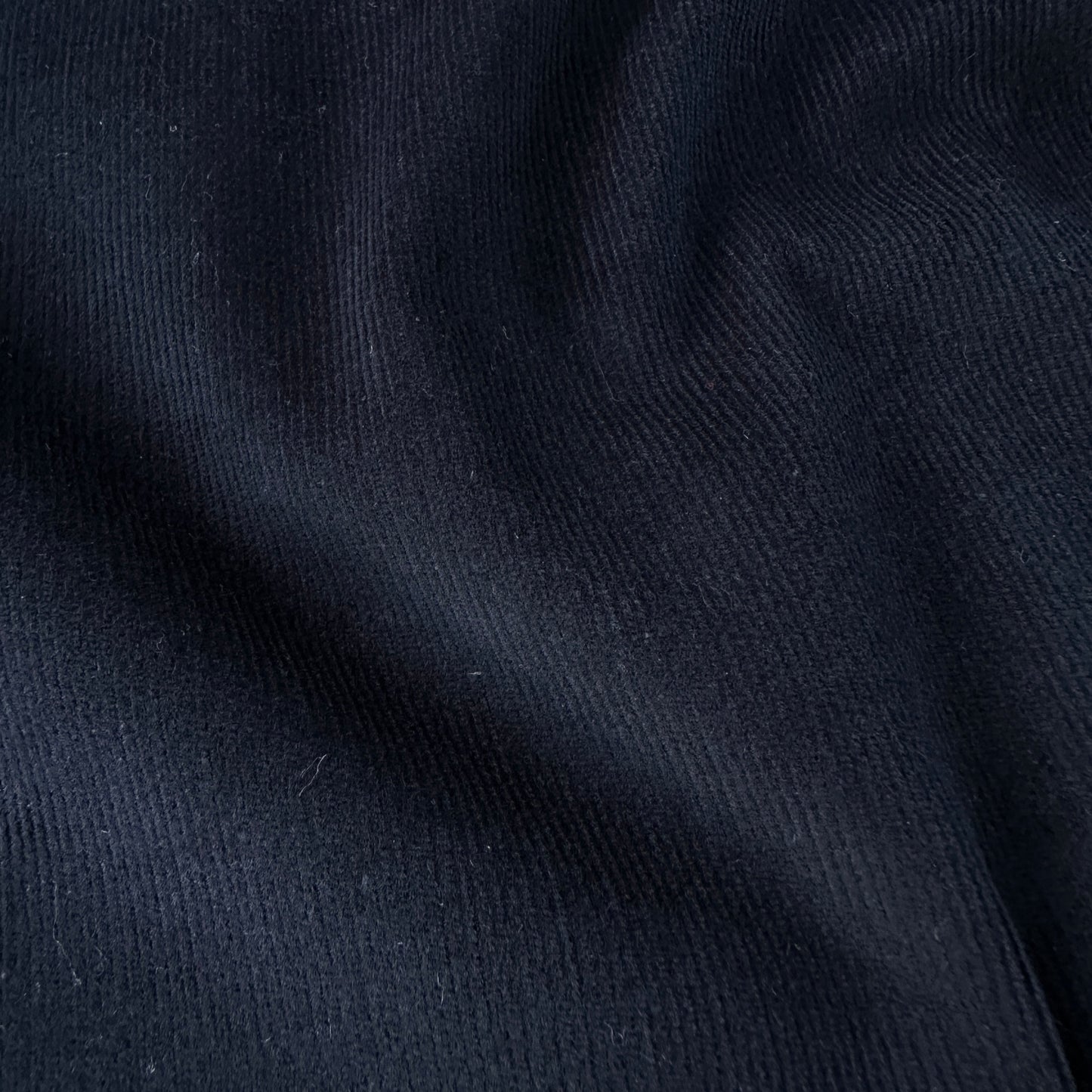 Close up of dark blue needlcord fabric texture