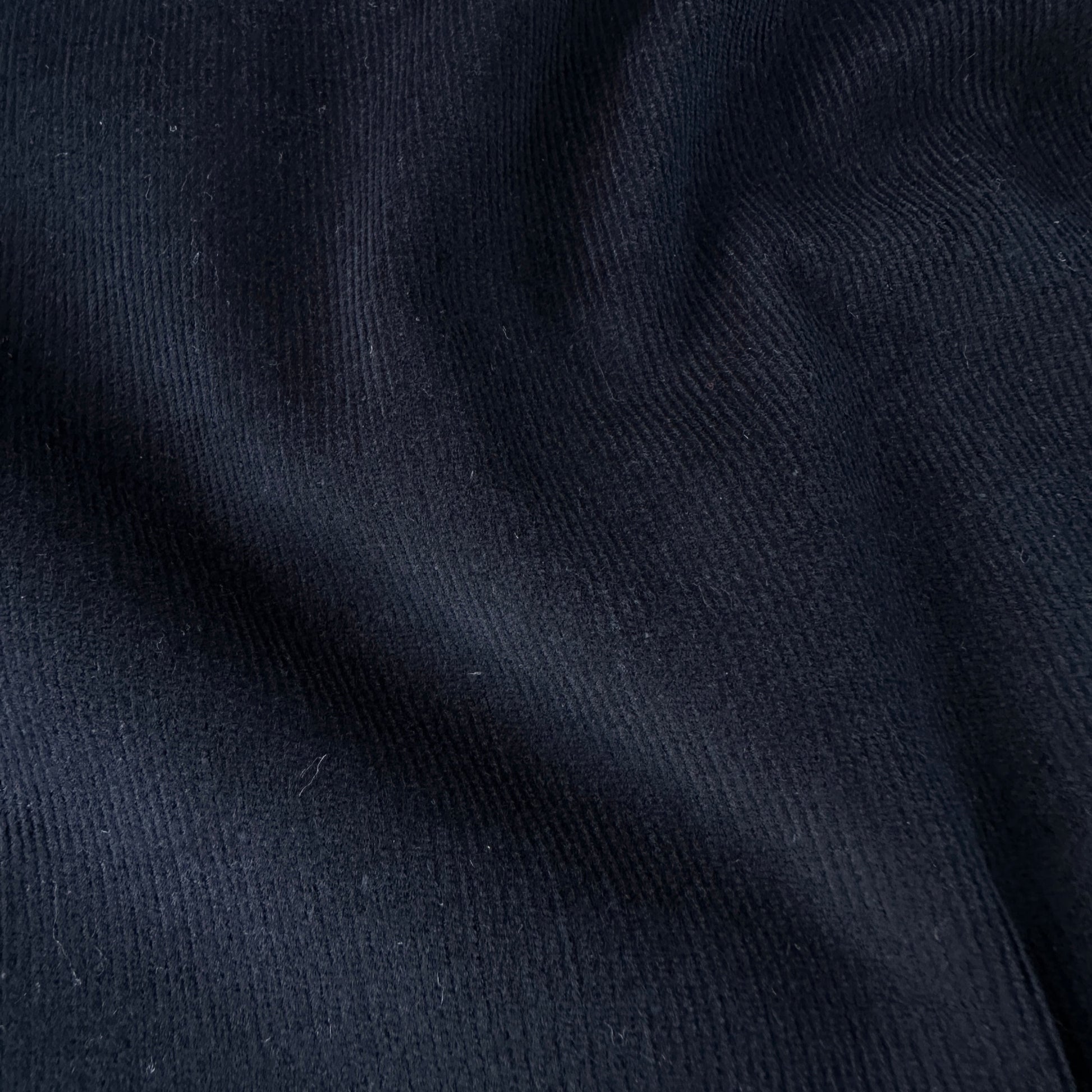 Close up of dark blue needlcord fabric texture