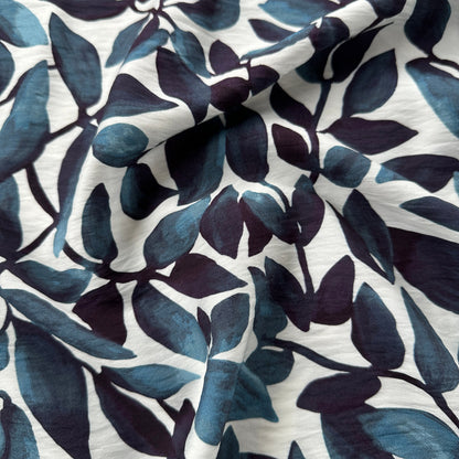 Close-up of fabric with blue leaf pattern on a white background