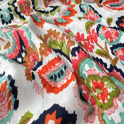 Close up of colourful paisley fabric with an off white background